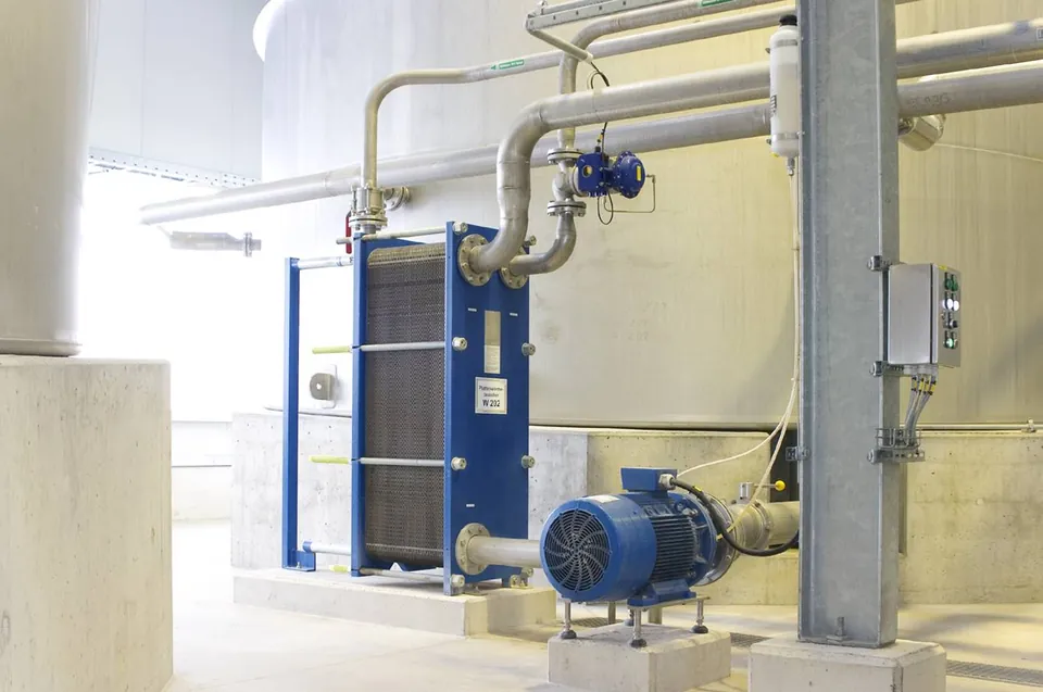 Blue-framed plate heat exchanger connected to a pump and pipework